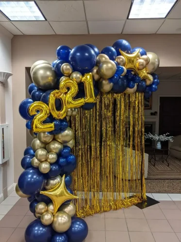 blueand+gold+balloon+garland+draped+over+a+gold+wall+with+2021+foil+numbers-1920w