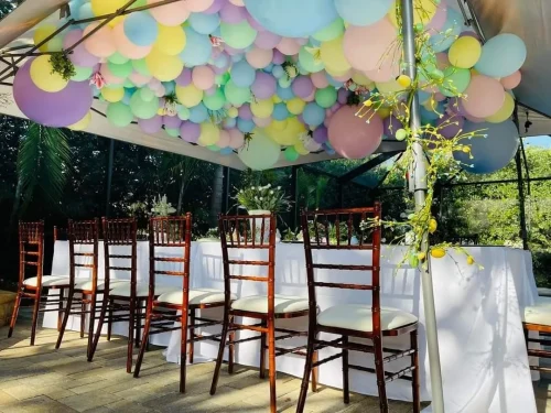 pastelballoons+floating+near+the+top+of+a+tent+at+an+outside+venue-1920w