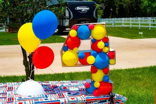 redyellow+and+blue+balloon+centerpieces+on+a+table+outside+in+the+shape+of+the+number+4-1920w